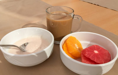 High angle view of citrus fruits by yoghurt and coffee on table