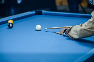 Midsection of woman playing pool
