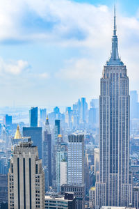 Modern buildings in city against cloudy sky