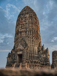 Low angle view of old temple against cloudy sky