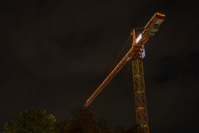 Low angle view of illuminated tower against sky at night