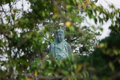 Low angle view of statue against trees