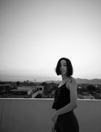 Young woman looking away against clear sky