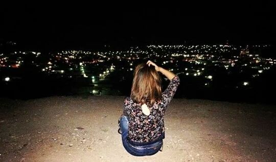 REAR VIEW OF WOMAN WITH ILLUMINATED HAIR AT NIGHT