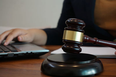 Midsection of person using laptop on table