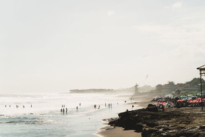 Group of people on beach against sky