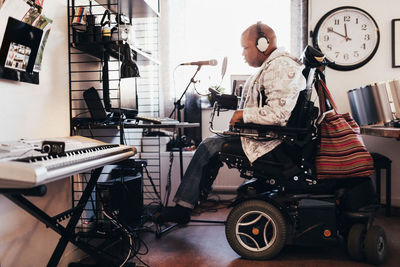 Side view of disabled musician with headphones in recording studio