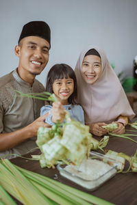 Portrait of smiling friends holding food at home