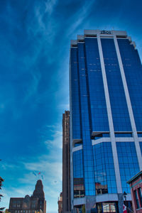 Low angle view of modern building against blue sky