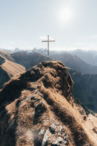 Cross on mountain against sky