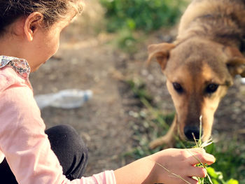 Close-up of little girl hand holding dog