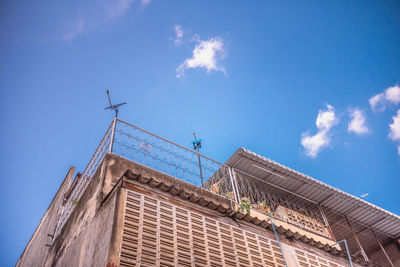 Low angle view of weather building against blue sky