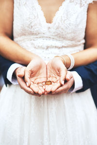Midsection of bride holding wedding ring