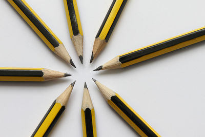 High angle view of colored pencils against white background