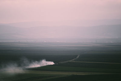 Scenic view of agricultural field against sky during sunset