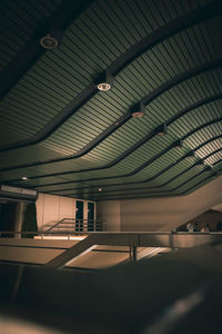 Low angle view of illuminated lights hanging on ceiling of building