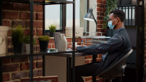 Side view of businessman working in office during pandemic