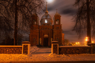 Illuminated historic building against sky at night during winter