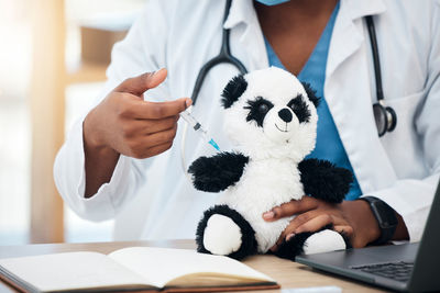 Midsection of doctor examining patient in hospital