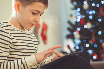 Boy using digital tablet at home during christmas