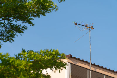 Low angle view of communications tower against clear blue sky