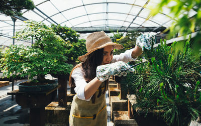 Woman standing by potted plants