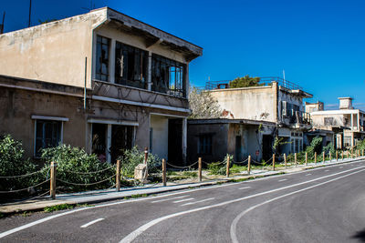 Street amidst buildings against clear blue sky