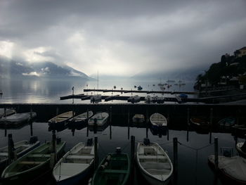 Boats moored at harbor against sky