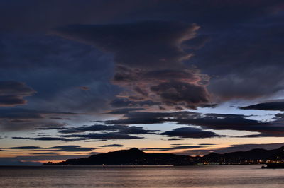 Scenic view of sea against dramatic sky during sunset