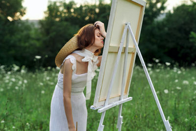 Rear view of woman standing against plants