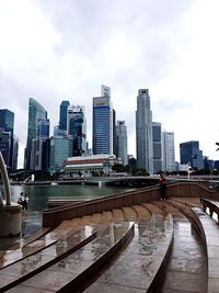 City at waterfront against cloudy sky