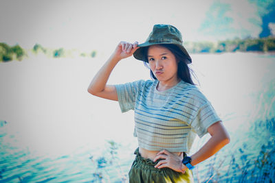 Portrait of young woman standing against plants