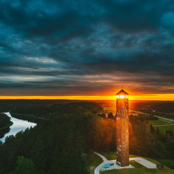 Scenic view of lighthouse and buildings against sky during sunset