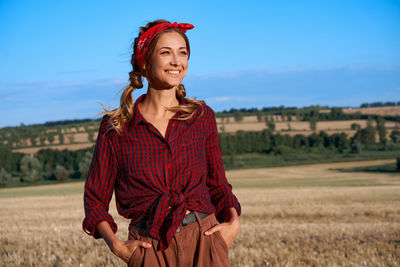 Portrait of smiling young woman standing on field