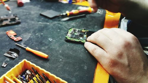 Cropped image of hand repairing mobile phone