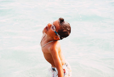 Full length of shirtless boy standing in sea