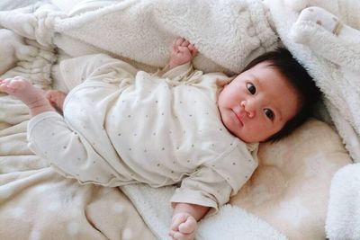 High angle portrait of cute baby lying on bed