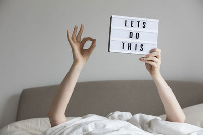 Low section of woman relaxing on bed at home