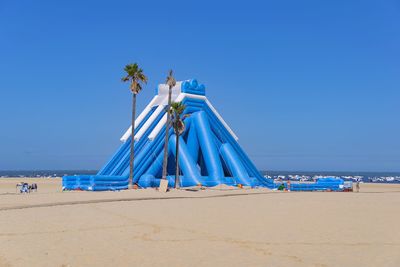 Panoramic view of beach against clear blue sky