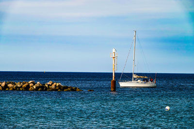 Sailboat sailing on sea against sky