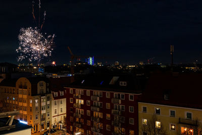 Firework display over illuminated buildings in city at night