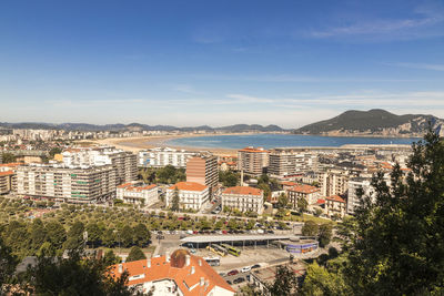 High angle view of townscape by sea against sky