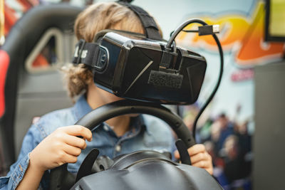 Rear view of boy photographing in car