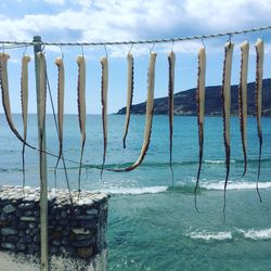 Wooden post in swimming pool by sea against sky