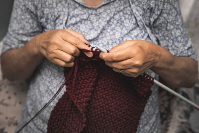 Midsection of woman knitting wool