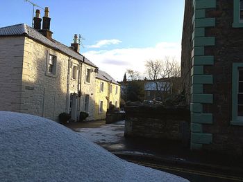 Street amidst buildings in town against sky