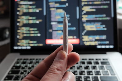 Cropped hand of woman using laptop