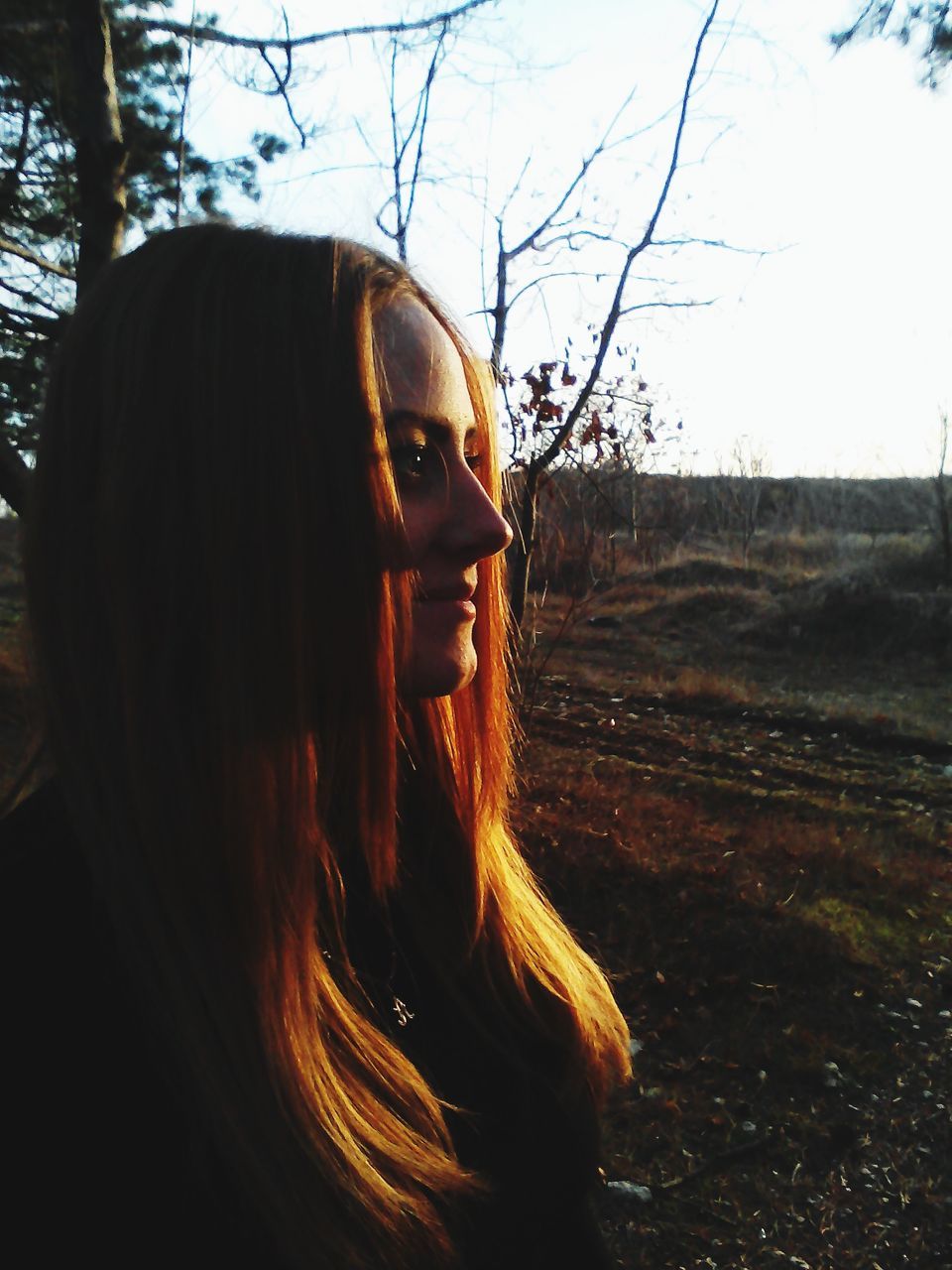 young adult, tree, headshot, lifestyles, young women, long hair, person, leisure activity, field, contemplation, front view, head and shoulders, sunlight, portrait, bare tree, standing, looking away, sunglasses