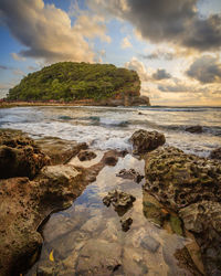 Scenic view of rocks on beach against sky