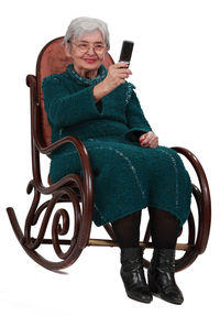 Full length of man sitting on chair against white background